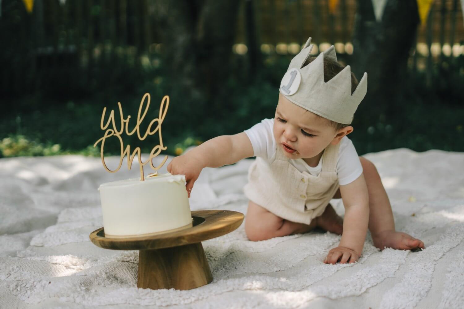 Newbornfotograaf Keerbergen — baby met kroontje bij verjaardagstaart